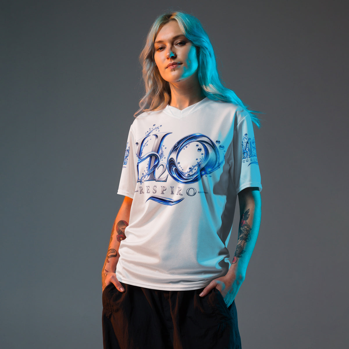 Maillot sport all over unisexe H2O RESPIRO blanc, porté par une femme, avec grand motif bleu sur la poitrine et fond gris neutre.