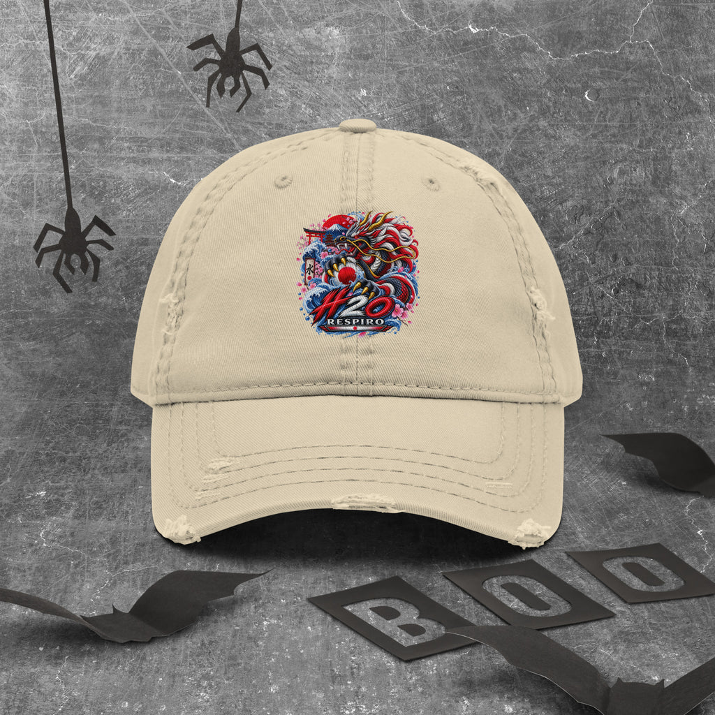 Casquette Dragon Flow – Édition Japon de H2O RESPIRO, en coton beige avec logo coloré brodé au centre, posée sur un fond gris texturé avec des toiles d’araignée décoratives.